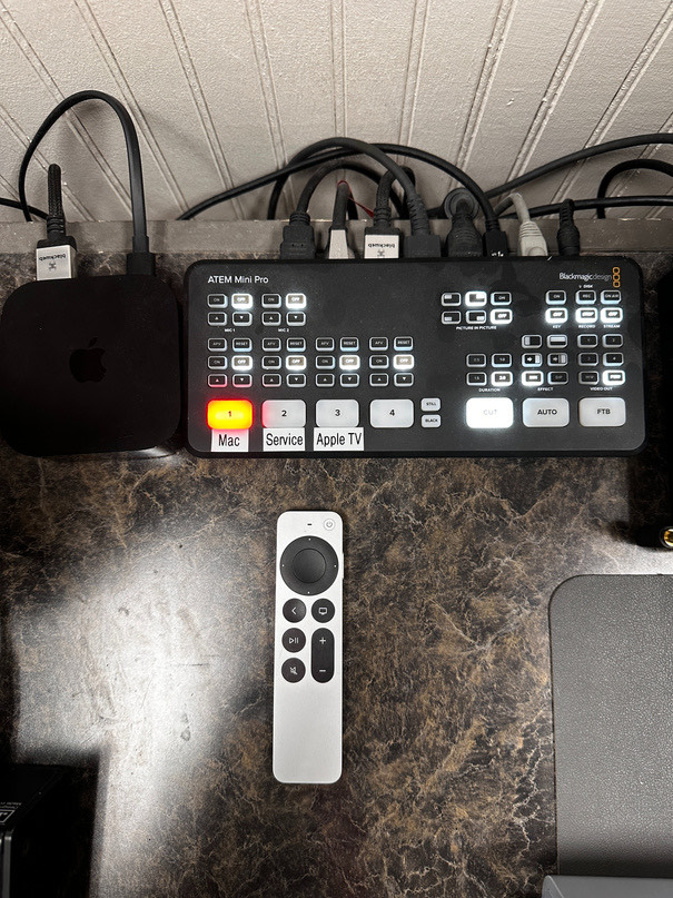 The Apple TV, its silver remote and the ATEM Mini on the desk
