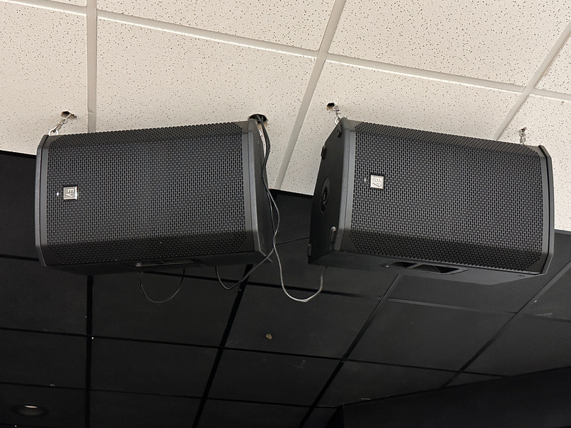 A pair of P.A. speakers mounted on the wall